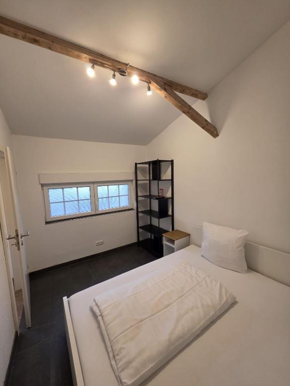 a bedroom with a white bed and a window at Maimühle Appartements in Perl