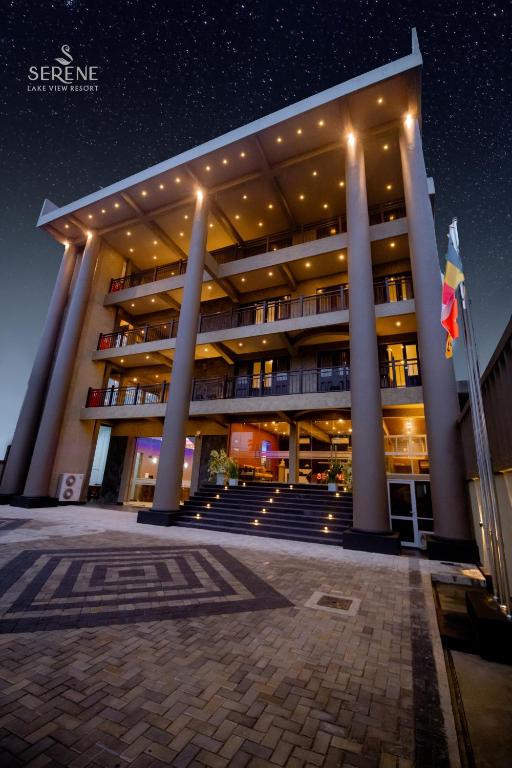 a large building with columns and stairs at night at Serene Lake View Resort in Anuradhapura