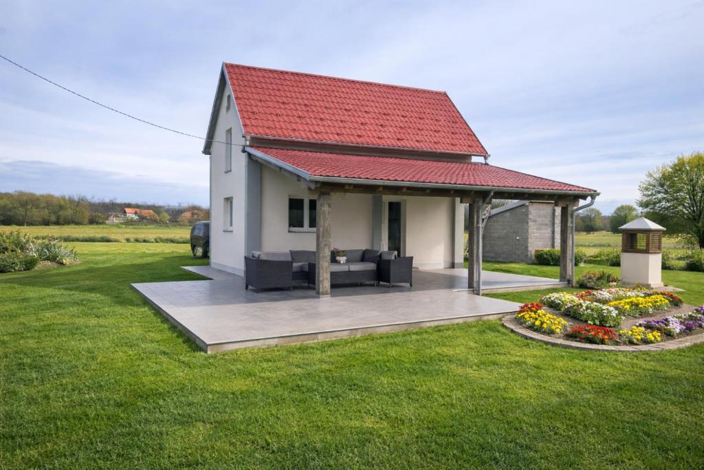 a small white house with a red roof at Holiday Home Kostandinovic in Modriča