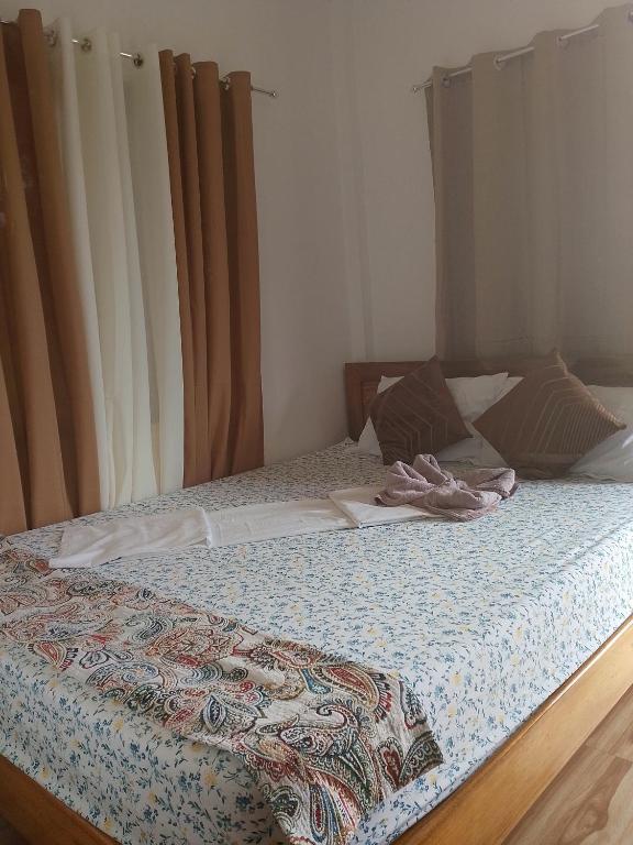 a bed with a quilt on it in a bedroom at Mangas Residents shared room in El Nido Airport