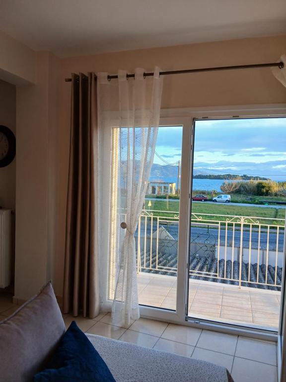 a living room with a sliding glass door to a balcony at Ioana Sea View in Corfu