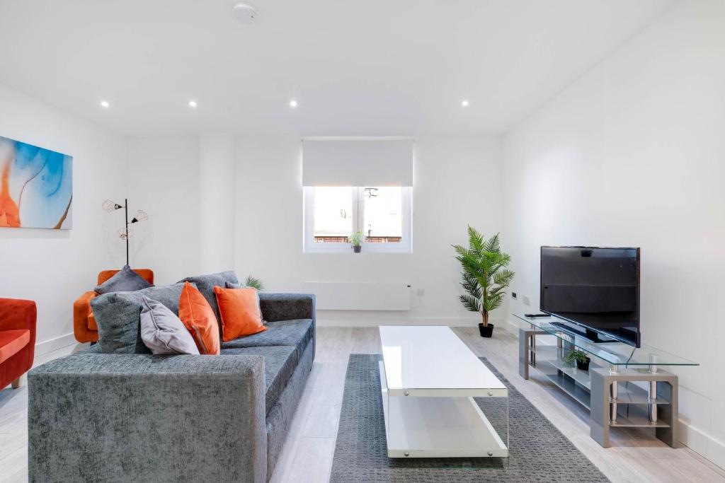a living room with a couch and a tv at Luxurious 1 Bed Serviced Apartment with Wi-Fi in Corby
