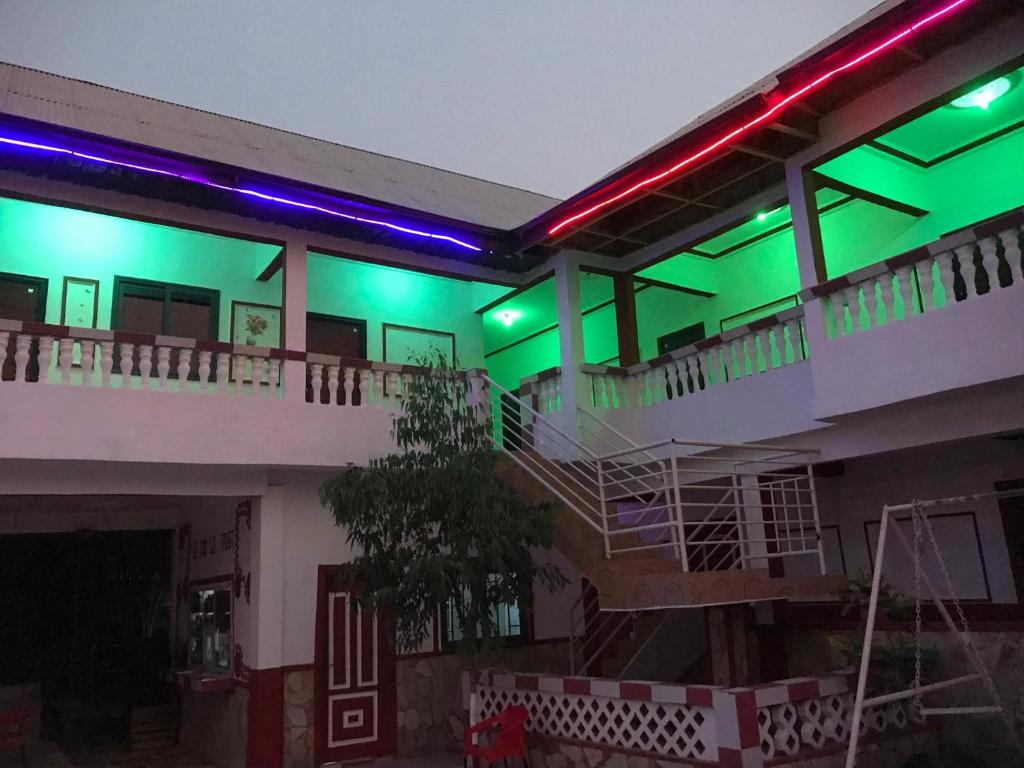 a building with green and purple lights on it at Alberjah Hotel in Atimpoko