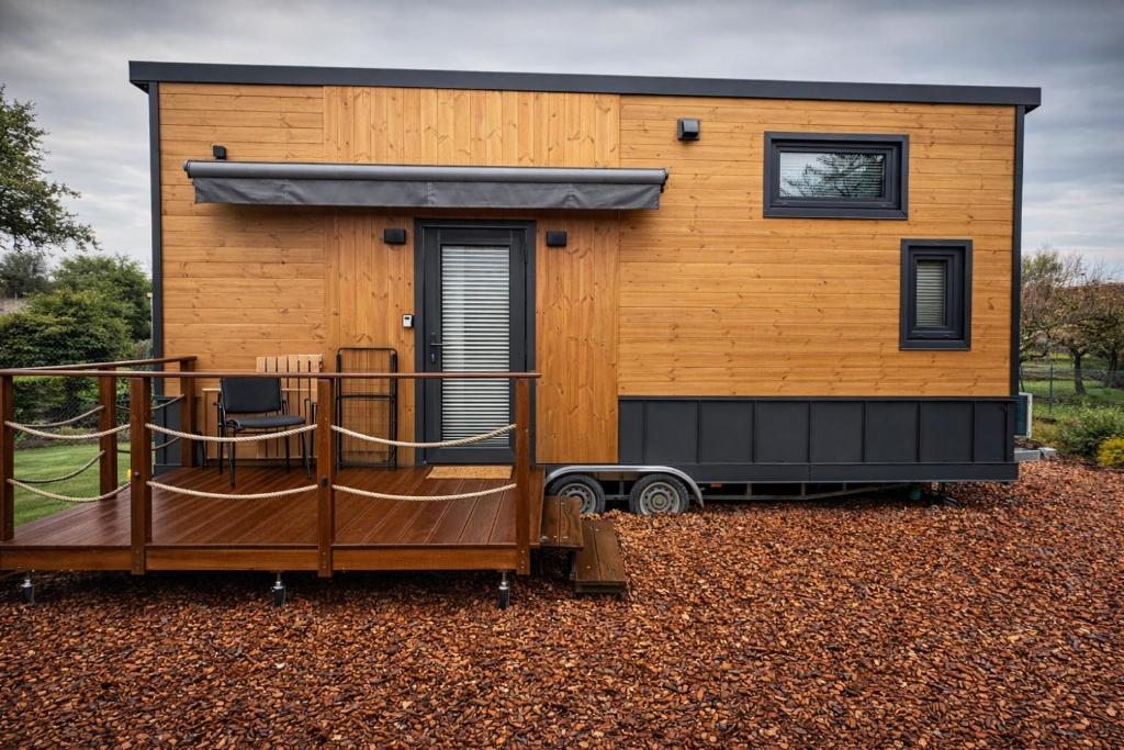a tiny house on a trailer with a porch at KE-Tiny-Siedlung Haus Buddy in Oerlenbach
