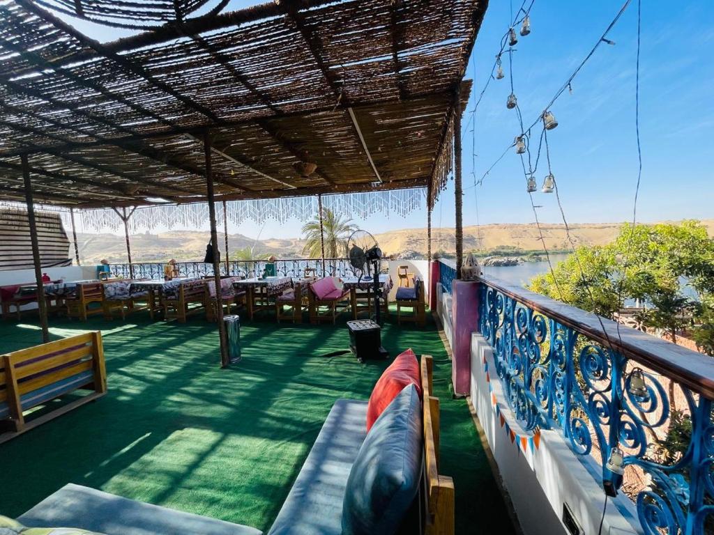 a balcony of a restaurant with tables and chairs at Bayt Zaina Nile View in Aswan