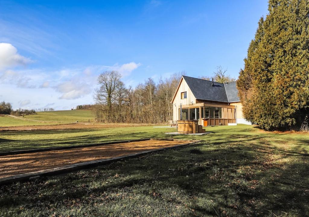 a house on a field with a train track in front at Le Gîte du Haras in Falaën