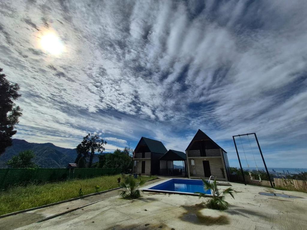 a cloudy sky above a swimming pool and a house at tsilo in Batumi