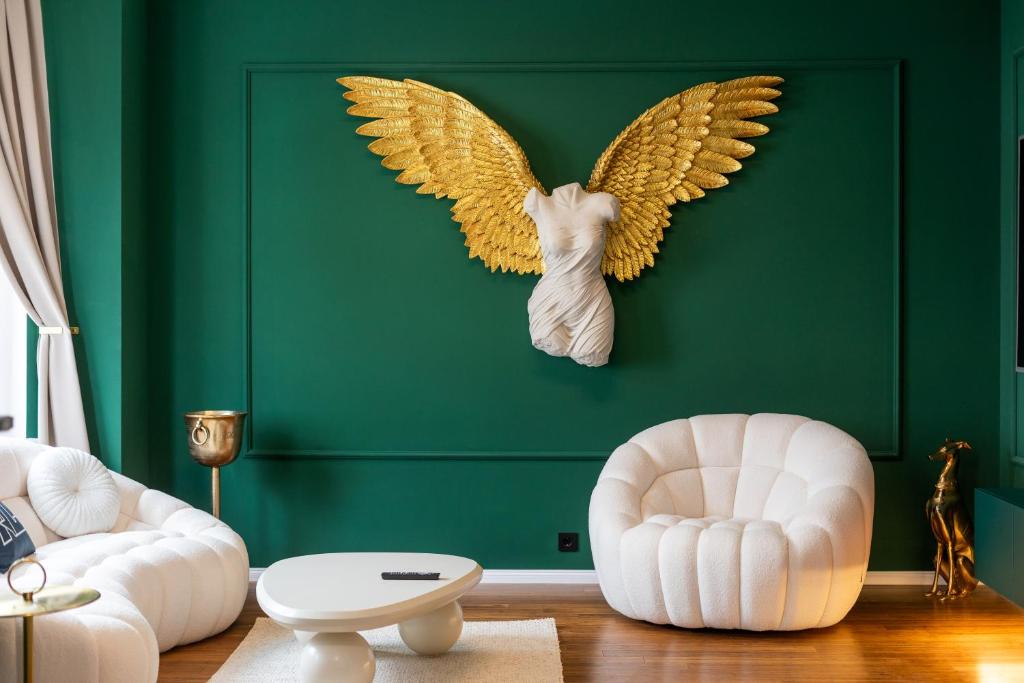 a green living room with an angel head on a green wall at Emerald Suite Design in Neumünster in Neumünster