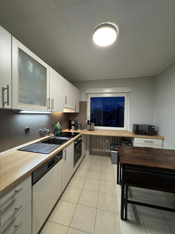 a kitchen with white cabinets and a wooden table at ZV38-Alter Weg-OG in Salzgitter