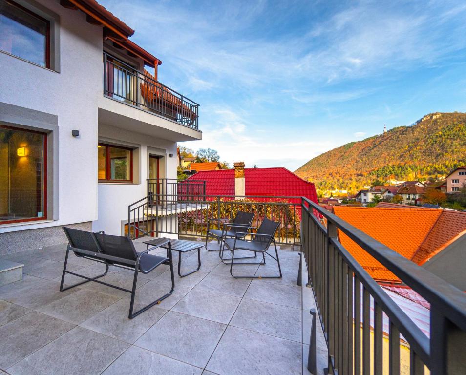 a balcony with chairs and tables on a building at Zen Den in Braşov