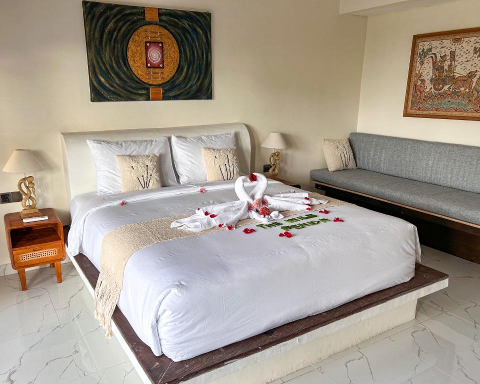 a bedroom with a large white bed with flowers on it at The Hills Penida in Nusa Penida