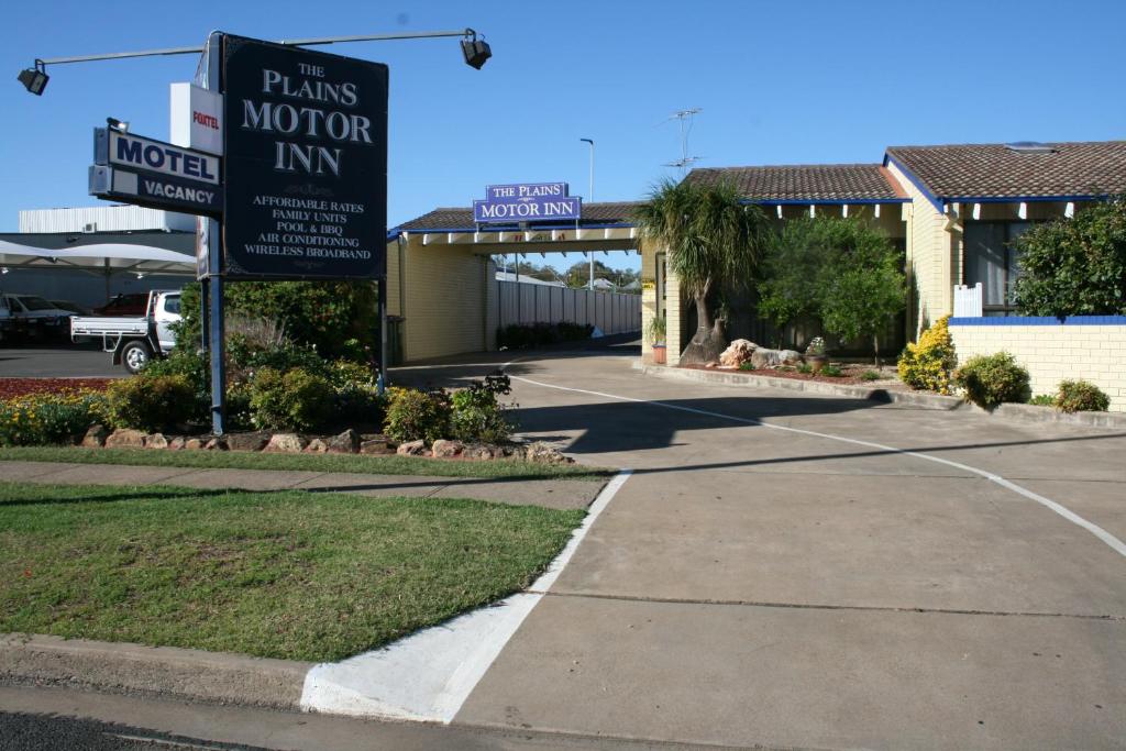 un letrero de la calle frente a un motel en The Plains Motor Inn, en Gunnedah