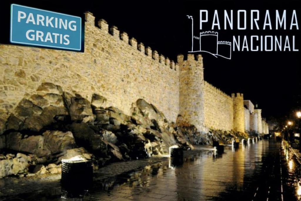 a stone wall with a street sign next to it at Panorama Nacional in Ávila