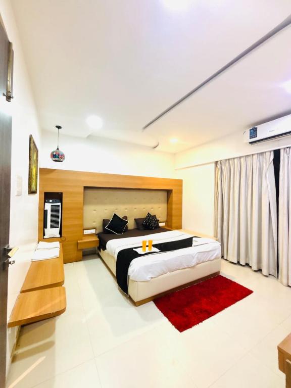 a bedroom with a large bed and a red rug at 3 bedroom Shreeji's Viila with Private pool in Lonavala