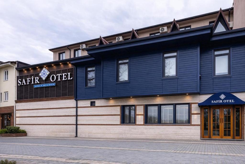 a blue building with a sign on the side of it at Safir Termal & Spa Otel in Çekirge İstasyonu
