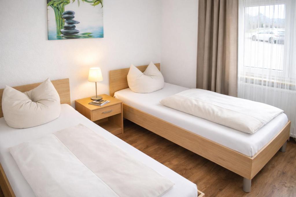 ein Hotelzimmer mit zwei Betten und einem Fenster in der Unterkunft Hotel Discovery in Stuttgart