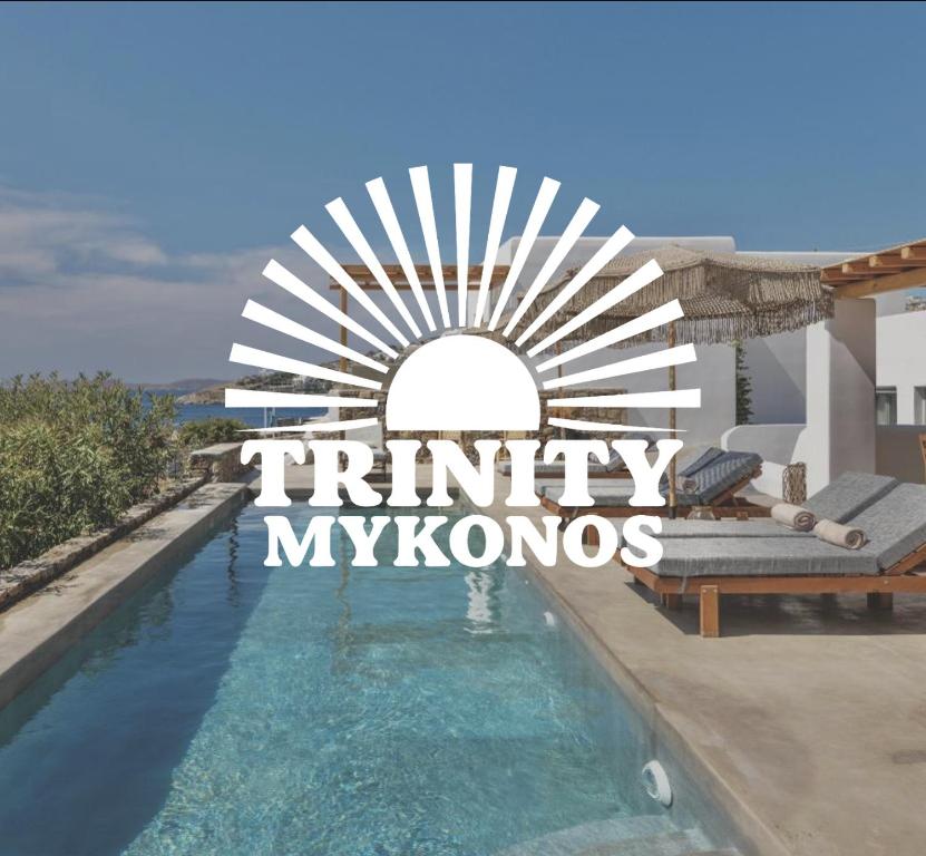 a villa with a swimming pool and a sign that reads triny myk at Trinity Mykonos - Beachfront Villa in Platis Gialos