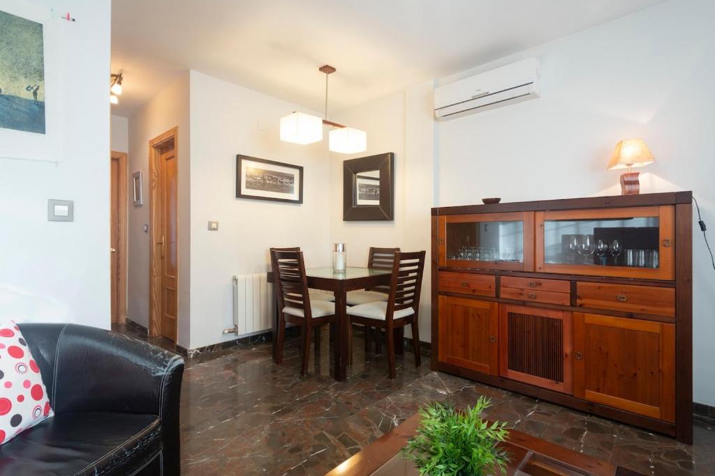 a living room with a table and a dining room at Casa modernista in La Zubia