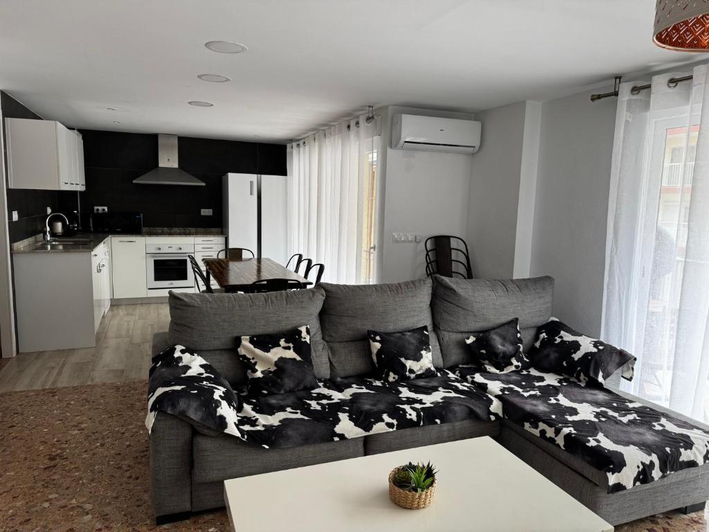 a living room with a gray couch with cow pillows at Don Quijote CABANAL in Cullera