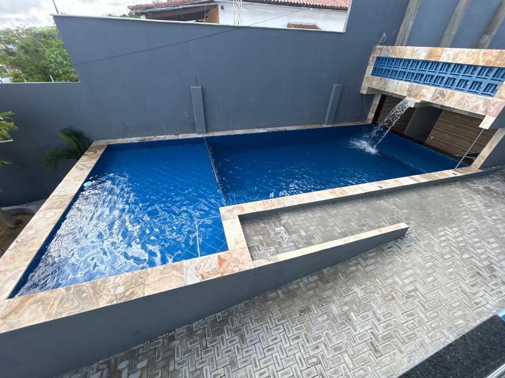a swimming pool with a waterfall in a house at Pousada coração da serra in Serra de São Bento