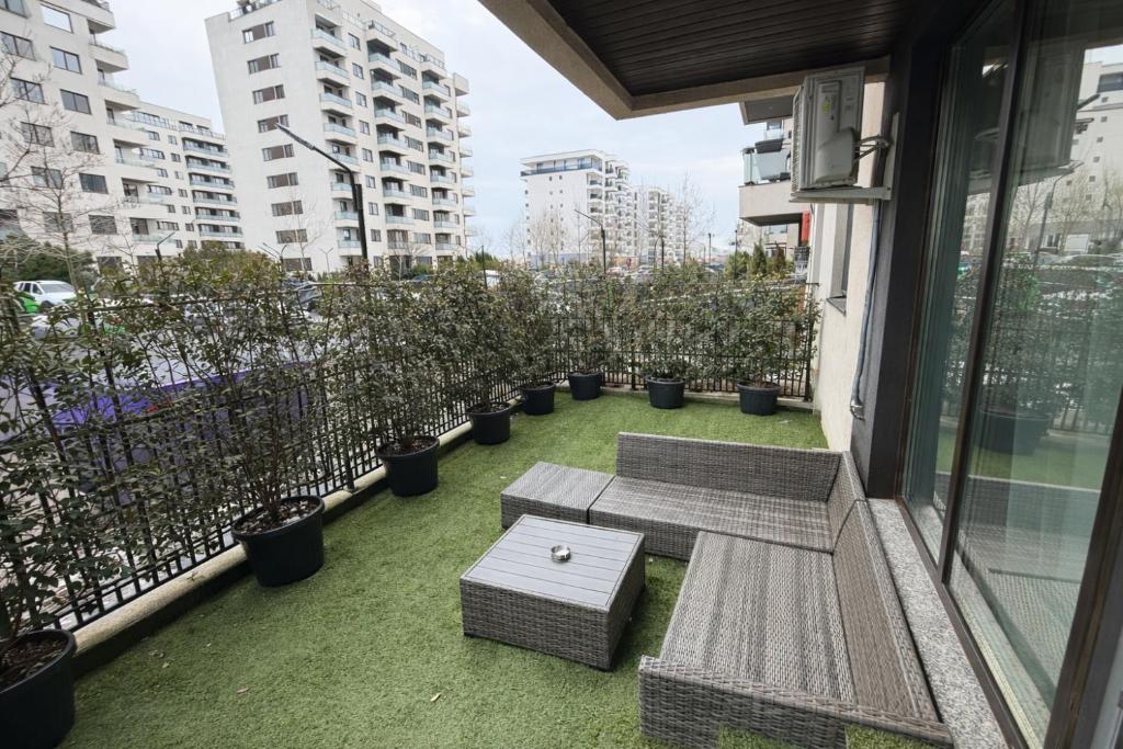 a balcony with benches and trees on a building at Sphynx Apartment Pipera in Voluntari
