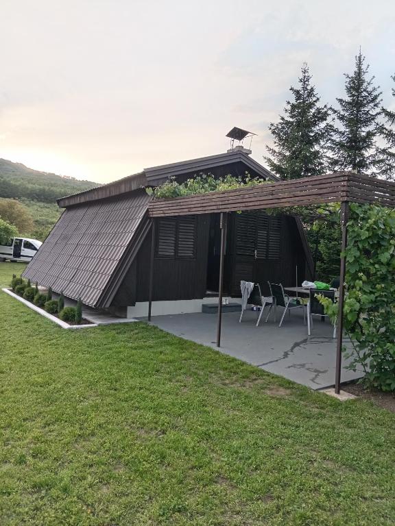 a pavilion with a table and chairs in a yard at Vikendica Uvac in Priboj