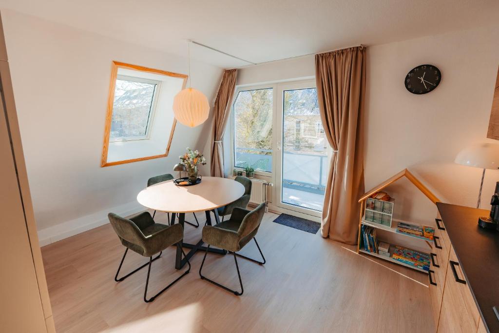 a dining room with a table and chairs and a window at Ferienwohnung Wirbelwind in Scharbeutz