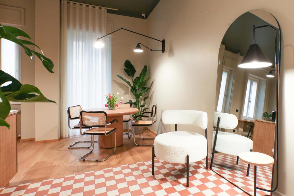 a room with a table and chairs and a mirror at Cà Bèla - Venini in Milan