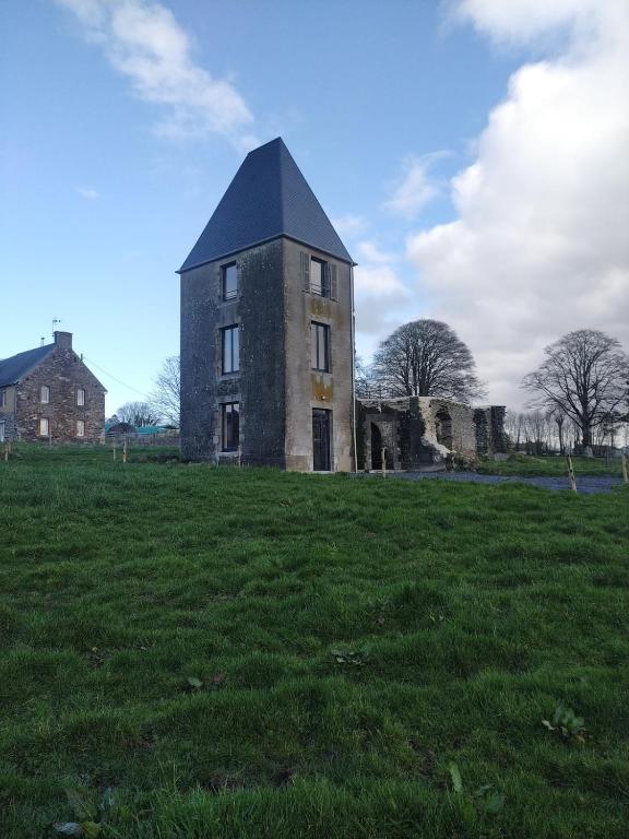 an old building in a field of grass at La Tour de Vesly in Belval