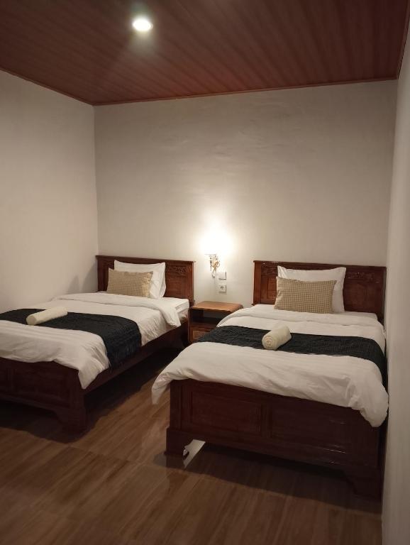 two beds in a room with at Traveling Guest House - Shared Kitchen in Kuta Lombok