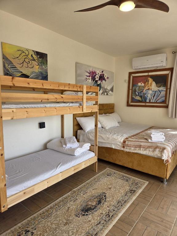 two bunk beds in a room with a ceiling at פסטרנק אירוח יער אודם in Odem
