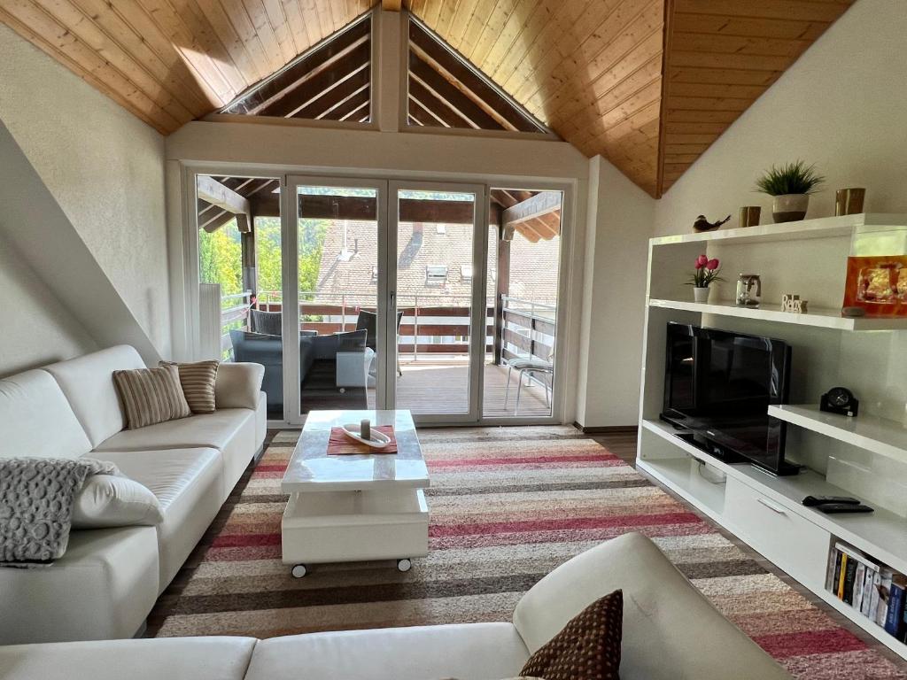 a living room with a white couch and a tv at Albbruck, Feriendomizil Albsteig in Albbruck