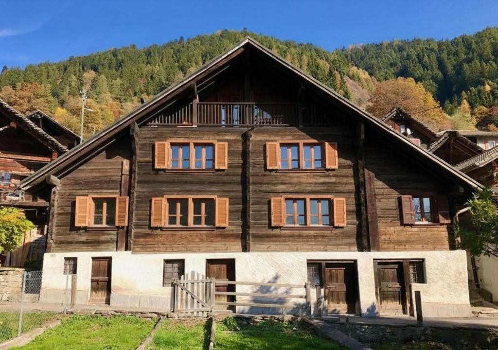 a large wooden house in the middle of a mountain at Relax alpino con sauna - Ca da Viola in Cavagnago