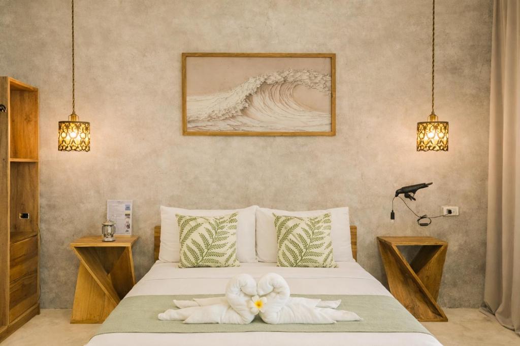 a bedroom with a bed with two towels on it at Moringa Private Room in General Luna