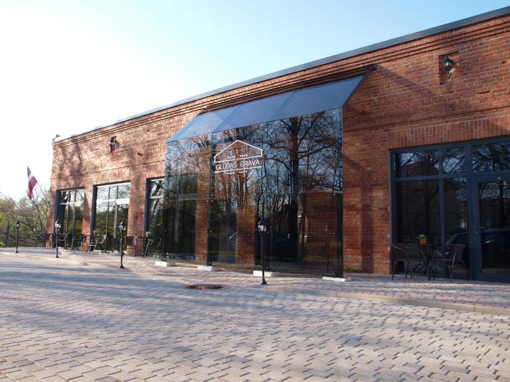 a brick building with large windows on a street at Glūdas Grava in Cēsis