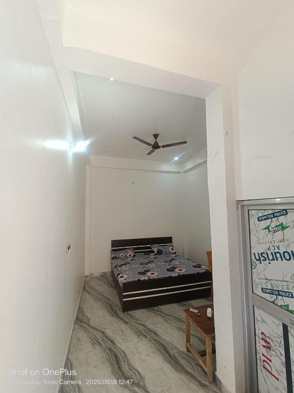 a room with a bed and a ceiling fan at Kaushlendra Bhawan in Ayodhya