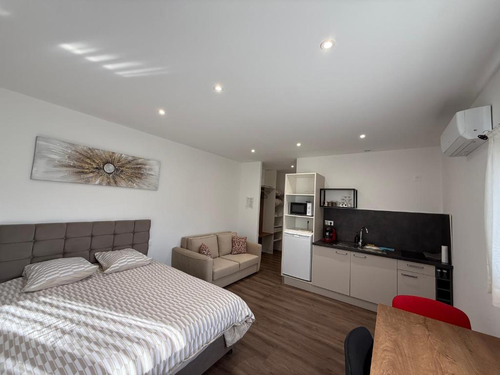 a bedroom with a bed and a kitchen and a table at Le 6 by Montélimar in Montélimar