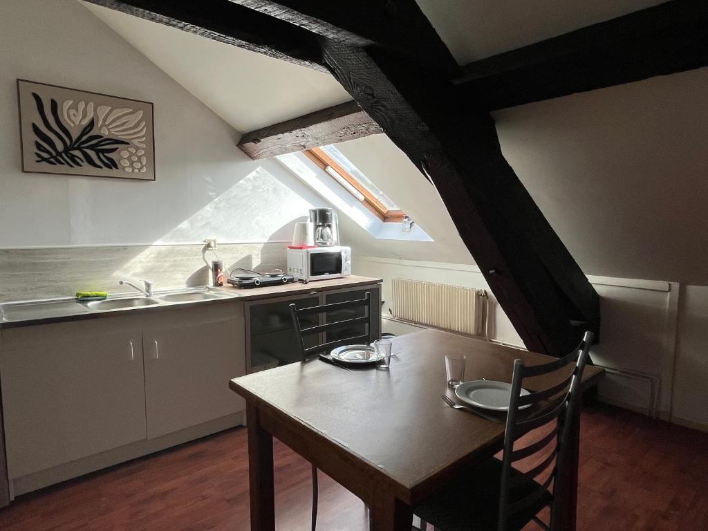 a kitchen with a table and a sink and a table and chair at Wood & Cosy in Thizy-les-Bourgs