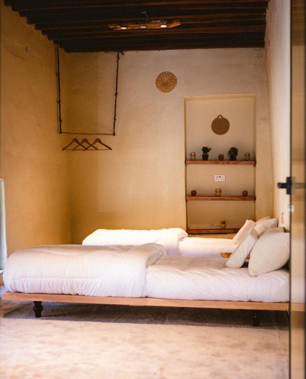 a large bed with white sheets and pillows in a room at Seet Room in Bilād Sayt