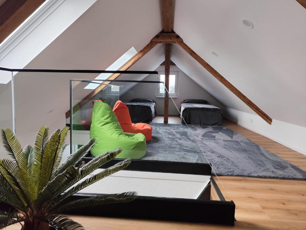 a living room with green and red chairs in a attic at FeWo Relaxfit in Bad Buchau