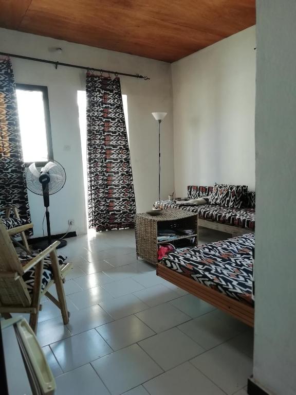a living room with a couch and chairs and a window at Maison Manour Studio 4 personen in Mbour