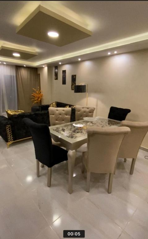 a dining room with a table and chairs and a couch at horizon sky pyramids in Cairo