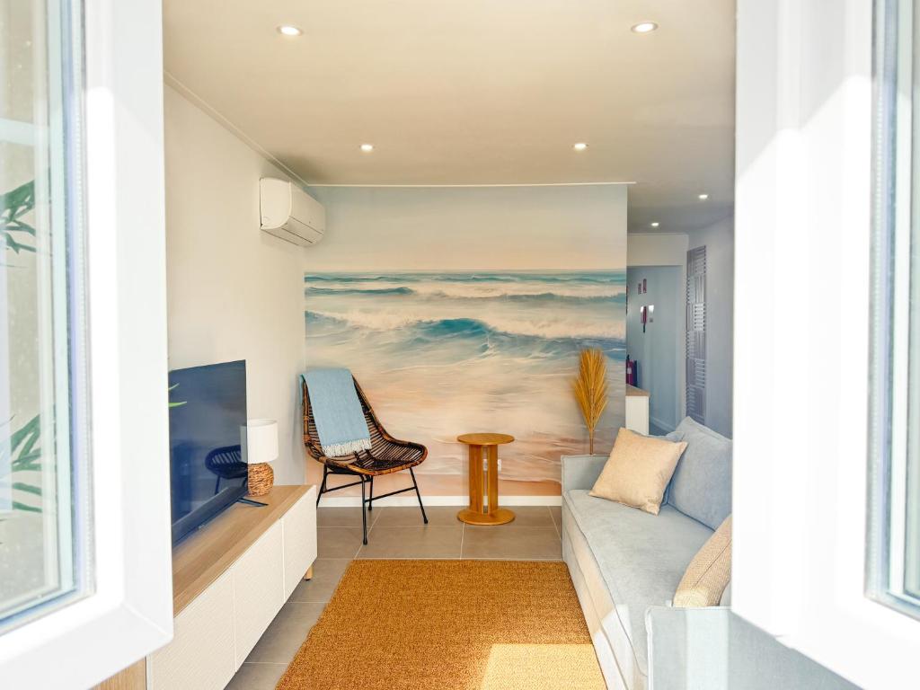 a living room with a couch and a painting of the ocean at Alma do Mar - Alma Nossa in Montijo