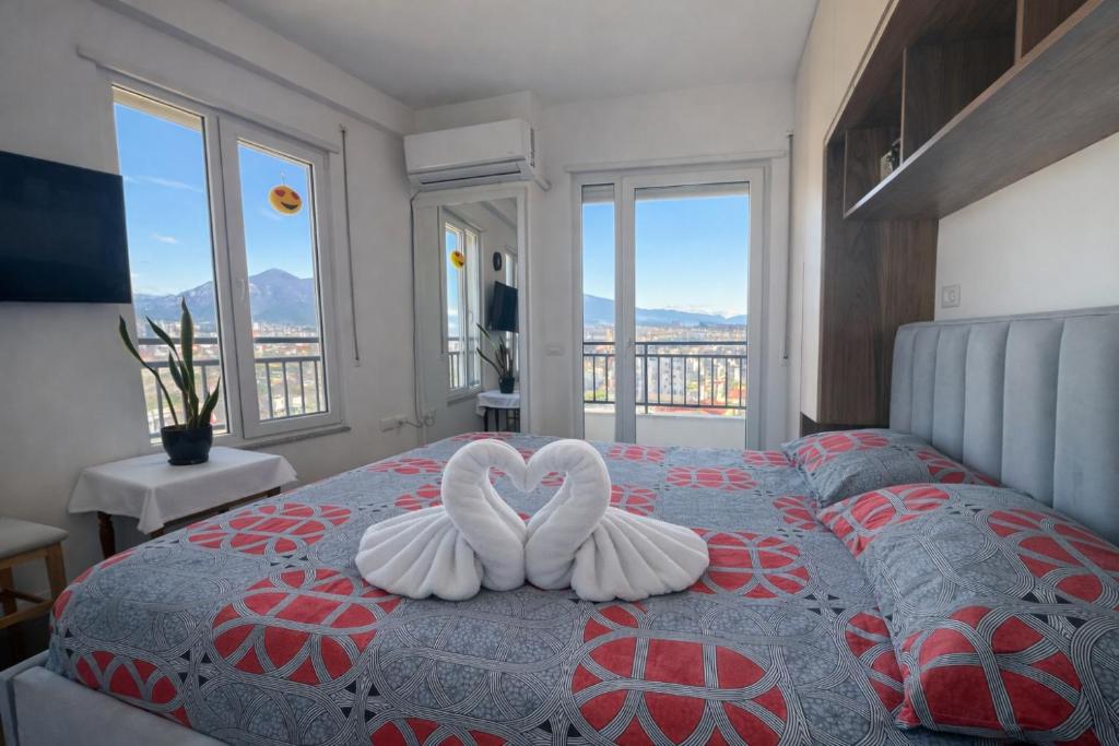 two swans forming a heart on a bed in a bedroom at Romantic Penthouse with Mountains View in Kashari