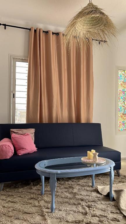 a blue couch with a table in a living room at Cozy Sousse Studio in Hammam Sousse