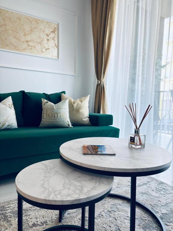 a living room with a green couch and a table at Adam Residence in Oradea