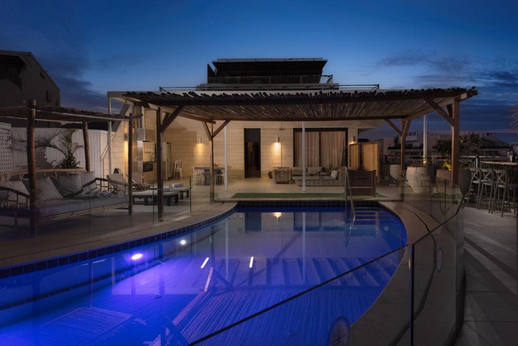 a swimming pool with a gazebo and a house at הבית על ההר - Ella Sun in Eilat