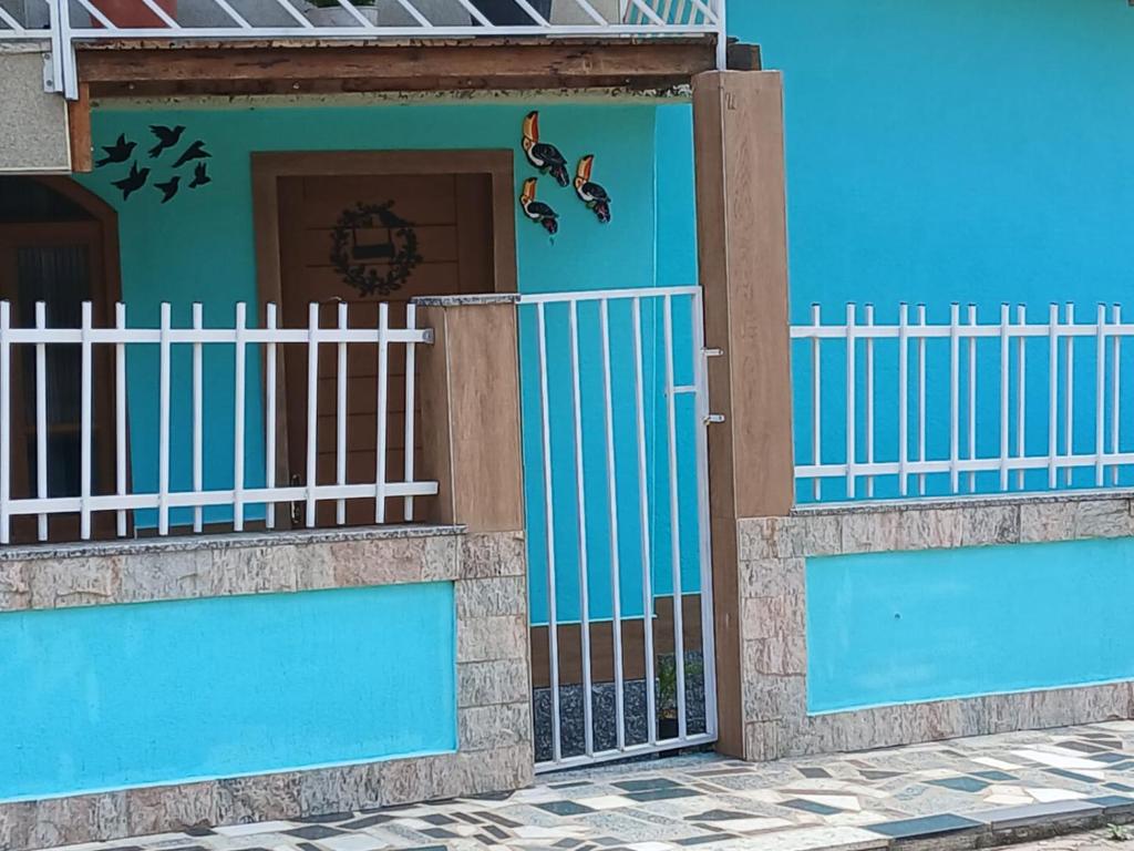 a blue house with a gate and a fence at Casa de Vivendas in Domingos Martins