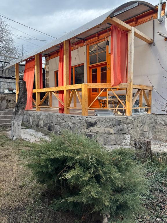a house with red curtains in front of it at Green Vibe Guesthouse in Vanadzor