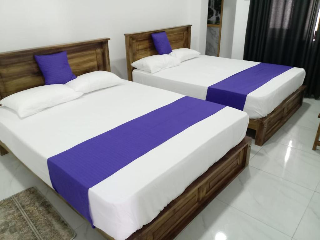 two beds sitting next to each other in a bedroom at Nil Manel Tourist in Anuradhapura